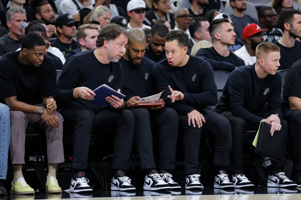 San Antonio Spurs assistant coaches Matt Nielsen, second from left to right, and Corliss Williamson talk to head coach Mitch Johnson as associate head coach Sean Sweeney watches the action on the court during the Spurs’ game against the Toronto Raptors at Frost Bank Center in San Antonio, Monday, Oct. 27, 2025. The Spurs defeated the Raptors, 121-103.