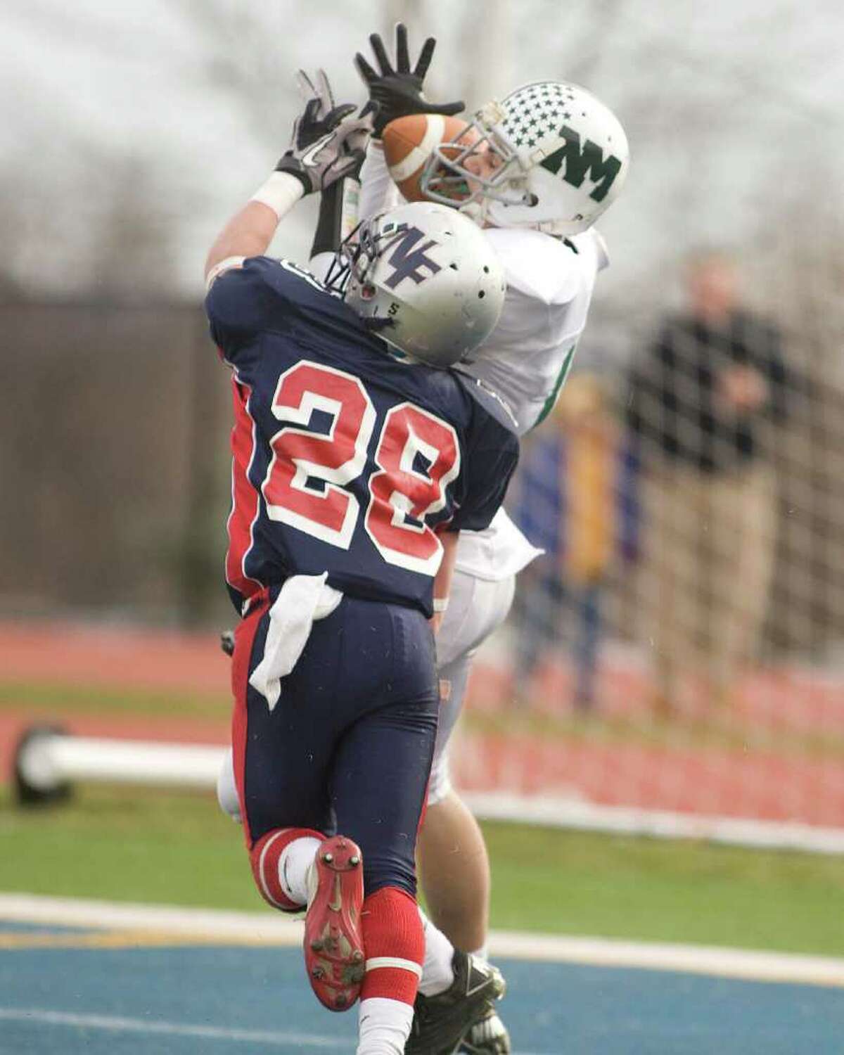 New Milford's Patrick Jordan catches a touchdown pass despite tight coverage by New Fairfield's Jimmy Andreozzi Thursday, Nov. 25, 2010 at New Fairfield High School.