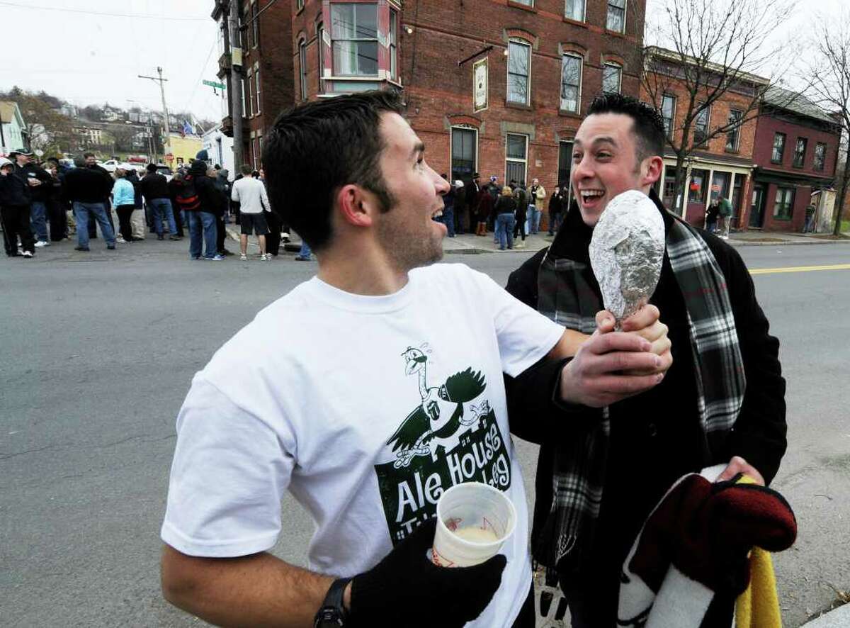 Mark Jensen shows off his "trophy", a turkey drumstick, after winning the run to the Ale House as he celebrates with his cousin Eamonn Greeran, at the annual Turkey Trot race in Troy November 25, 2010. (SKIP DICKSTEIN / TIMES UNION)