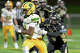 Holy Cross’ Dae’Sean Graves (1) tries to slip free from WCA’s Jaiden Rousseau (9) during their game Friday, October 31, 2025 at Municipal Stadium in Waterbury, Conn.