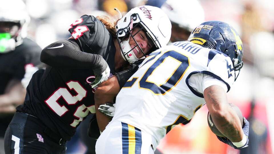 Houston defensive back Wrook Brown (24) tackles West Virginia running back Diore Hubbard (20) for a loss during the first half of a NCAA college football game at TDECU Stadium in Houston, Saturday, Nov. 1, 2025.