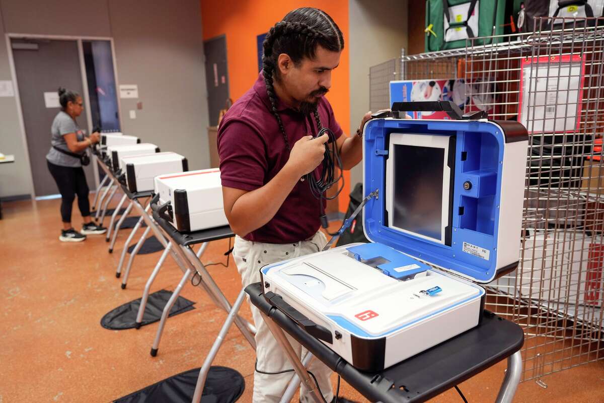 Erik Muñoz, a Republican precinct chair in Pasadena, helps set up a polling place at a Baker Ripley center in Houston, Monday, Nov. 3, 2025.