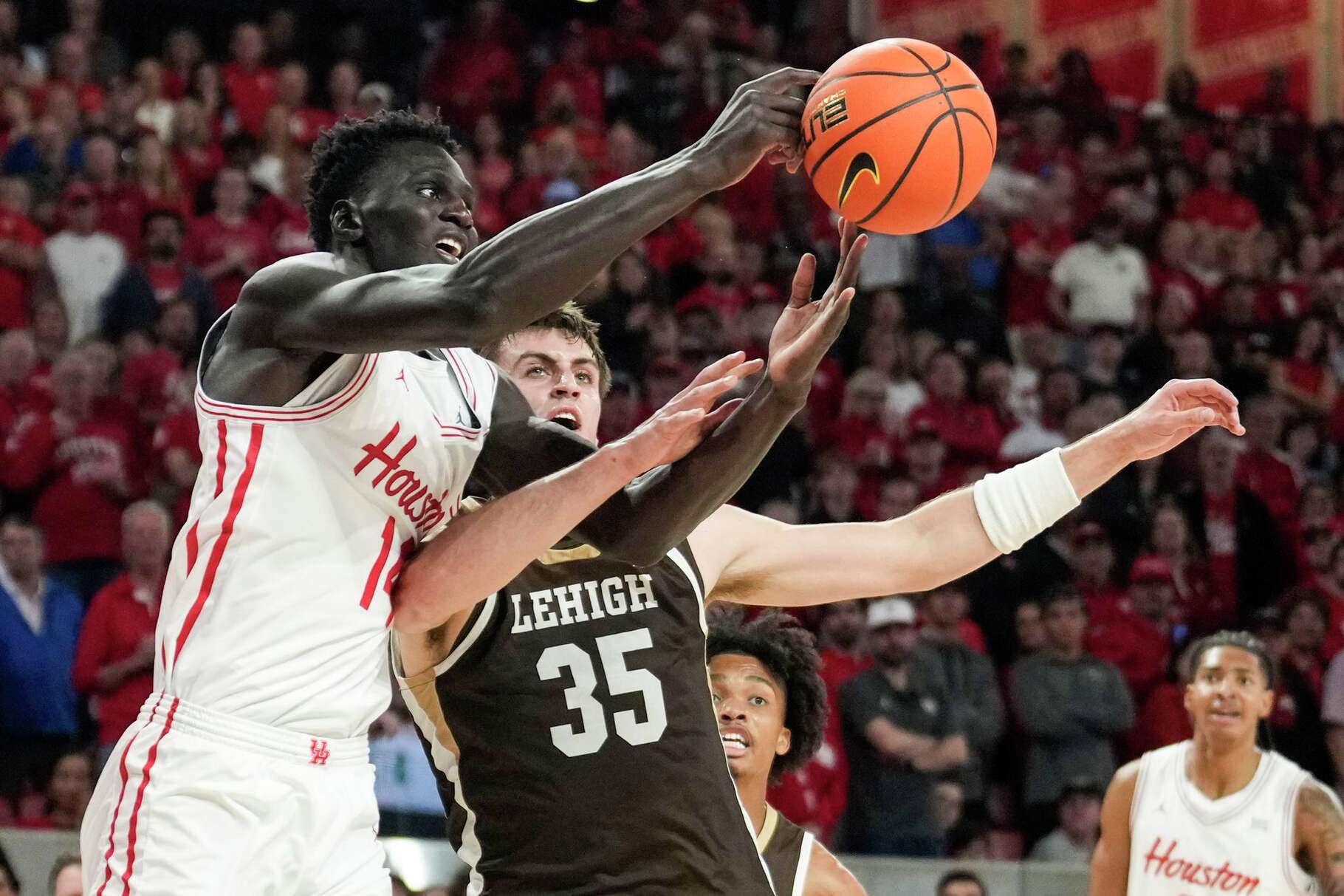 Houston forward Kalifa Sakho (14) and Lehigh forward Hank Alvey (35) fight for a rebound during the first half of an NCAA college basketball game at Fertitta Center in Houston, Monday, Nov. 3, 2025.