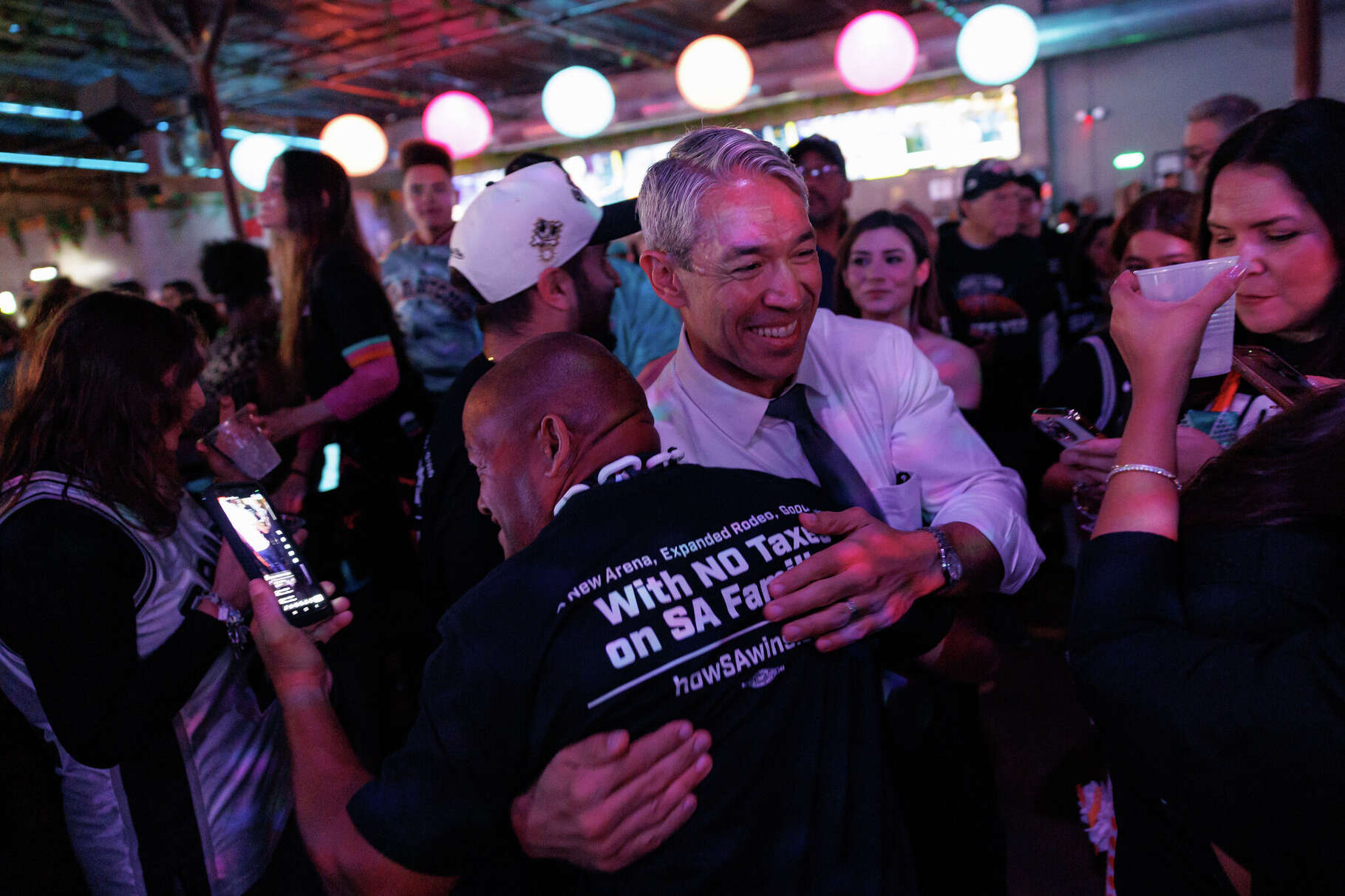 Former Mayor Ron Nirenberg embraces an excited San Antonio Spurs fan as they celebrate the passage of Proposition B at an election watch party at River North Icehouse in San Antonio, Tuesday, Nov. 4, 2025. Nirenberg publicly backed Propositions A and B before the election.