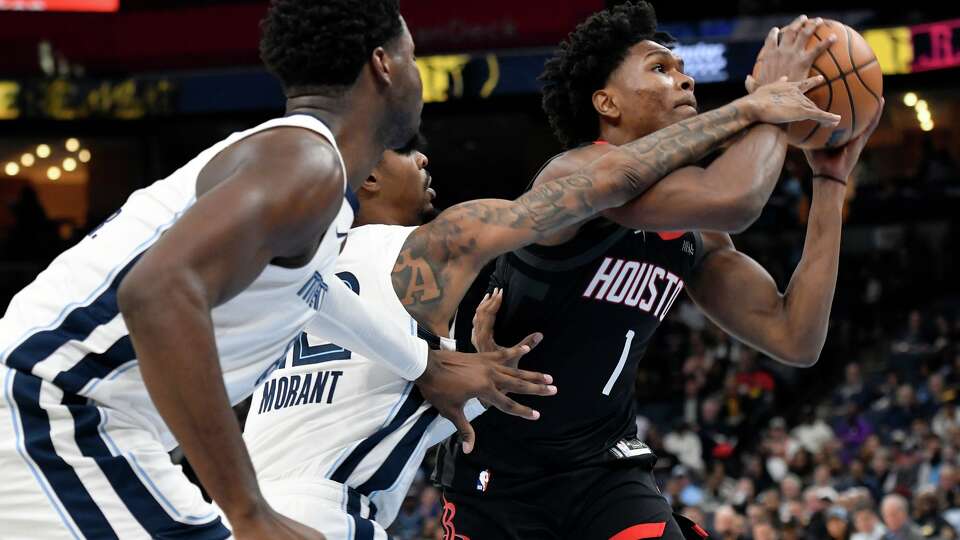 Houston Rockets guard Amen Thompson (1) handles the ball ahead of Memphis Grizzlies guard Ja Morant, center, and forward Jaren Jackson Jr. in the first half of an NBA basketball game Wednesday, Nov. 5, 2025, in Memphis, Tenn. (AP Photo/Brandon Dill)