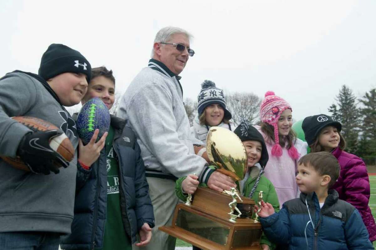 Norwalk Coach Pete Tucci and his grandchildren pose with the Sam Testa Trophy Thanksgiving Day, November 25, 2010. The Bears beat McMahon in a crosstown bout 8-7 in what was Tucci's final game.