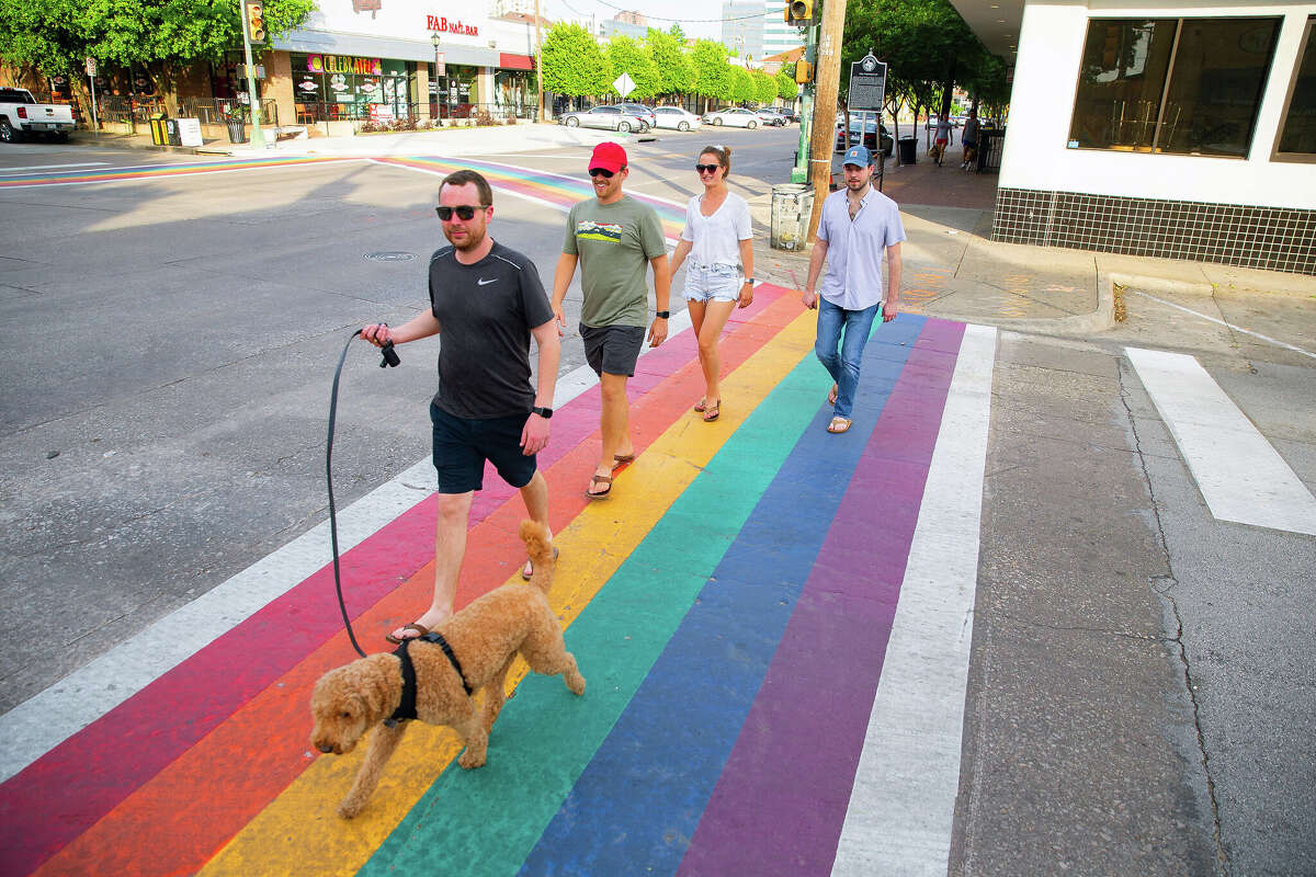 A group walks on a rainbow crosswalk on Cedar Springs at Throckmorton Street in Oak Lawn on May 1, 2020. 
