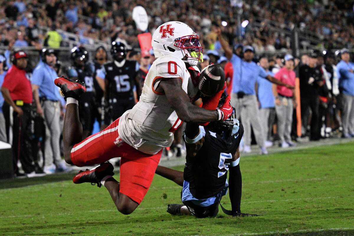 Houston wide receiver Amare Thomas (0) has a pass broken up by Central Florida defensive back DJ Bell (5) during the first half of an NCAA college football game, Friday, Nov. 7, 2025, in Orlando, Fla. (AP Photo/Phelan M. Ebenhack)