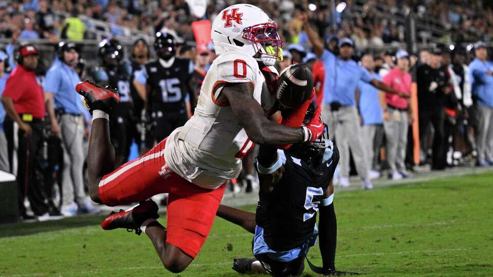 Houston wide receiver Amare Thomas (0) has a pass broken up by Central Florida defensive back DJ Bell (5) during the first half of an NCAA college football game, Friday, Nov. 7, 2025, in Orlando, Fla. (AP Photo/Phelan M. Ebenhack)