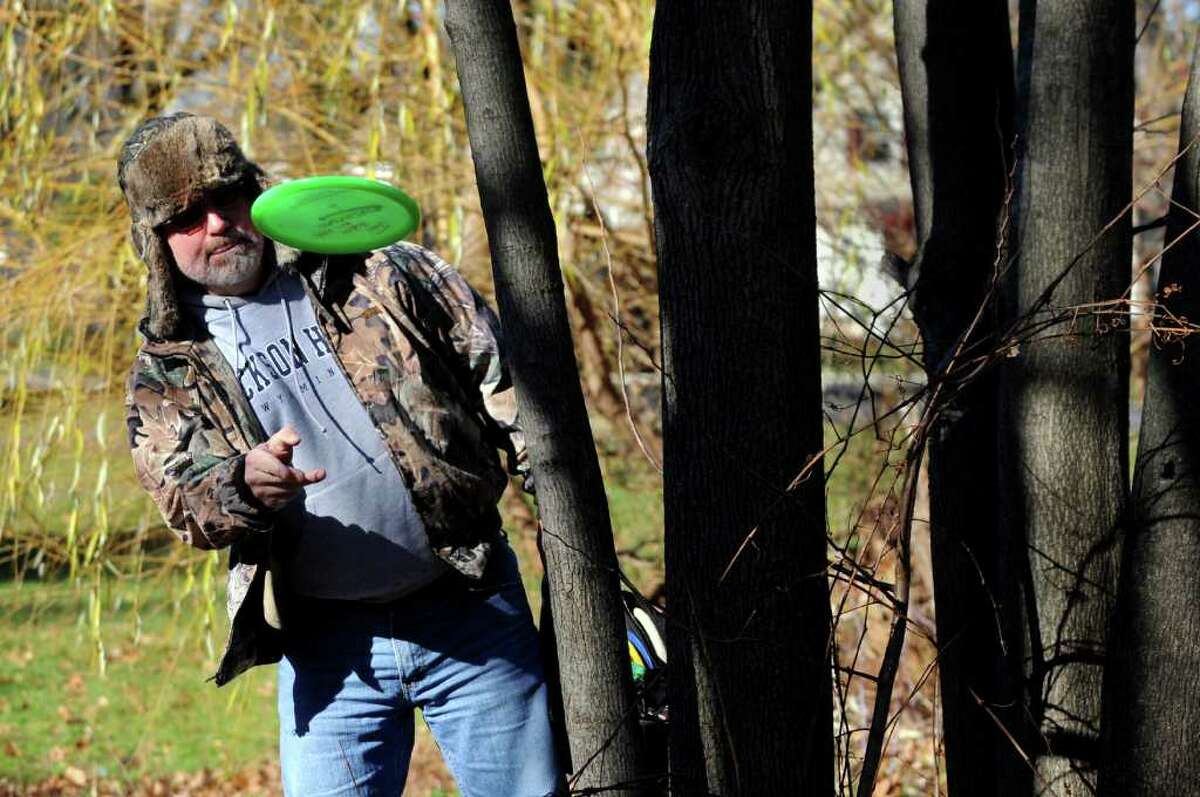 John Vendetti of Glenville has to avoid a natural obstacle on the disc golf course on Wednesday, Nov. 24, 2010, at Central Park in Schenectady, N.Y. At right is his brother Joe. (Cindy Schultz / Times Union)