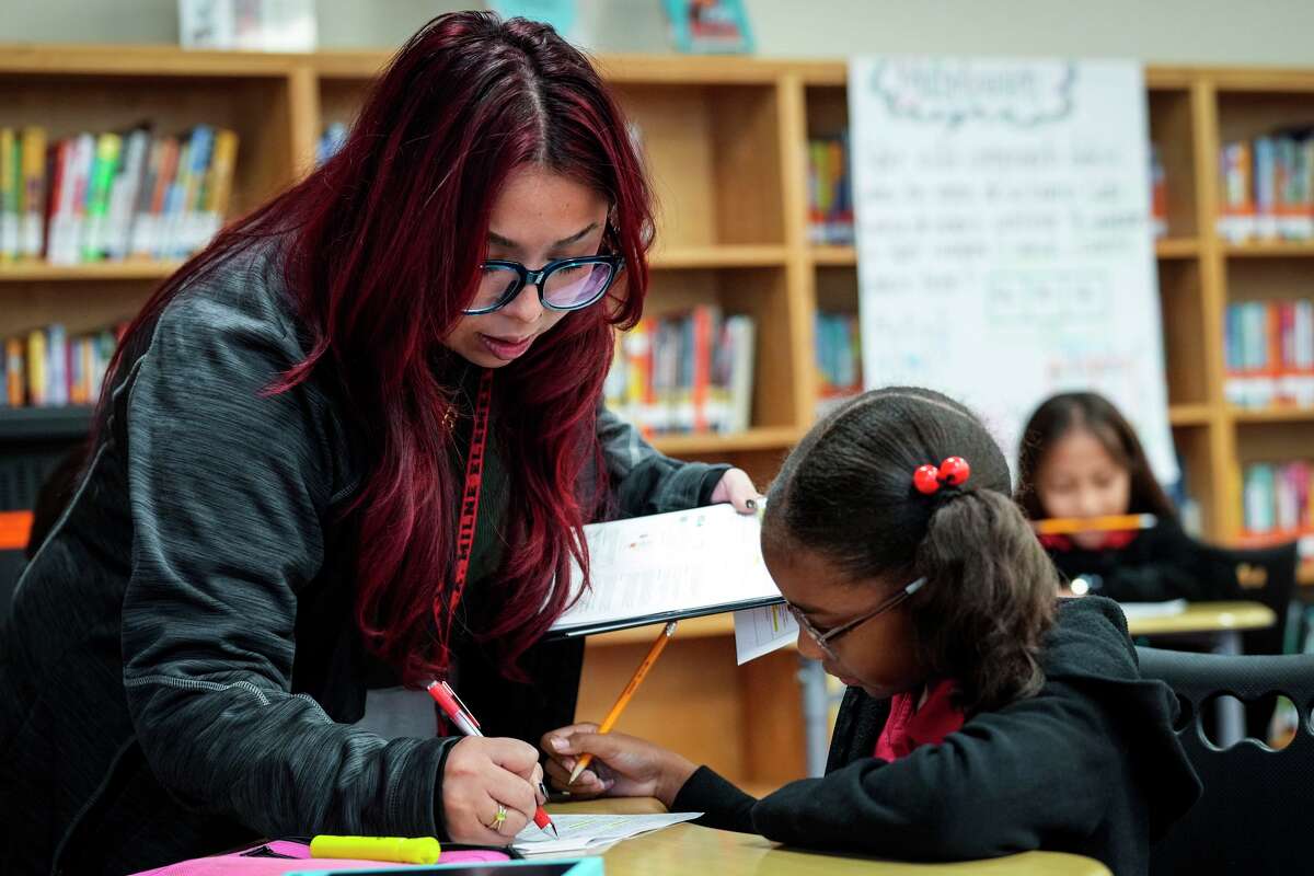 Learning Coach Valeria Boulouf works with Madison Decuir on her classwork at HISD’s A.A. Milne Elementary School in Houston, Wednesday, Nov. 12, 2025. HISD's Milne Elementary School is second most improved elementary schools in the Houston area according to Children At Risk's annual rankings.