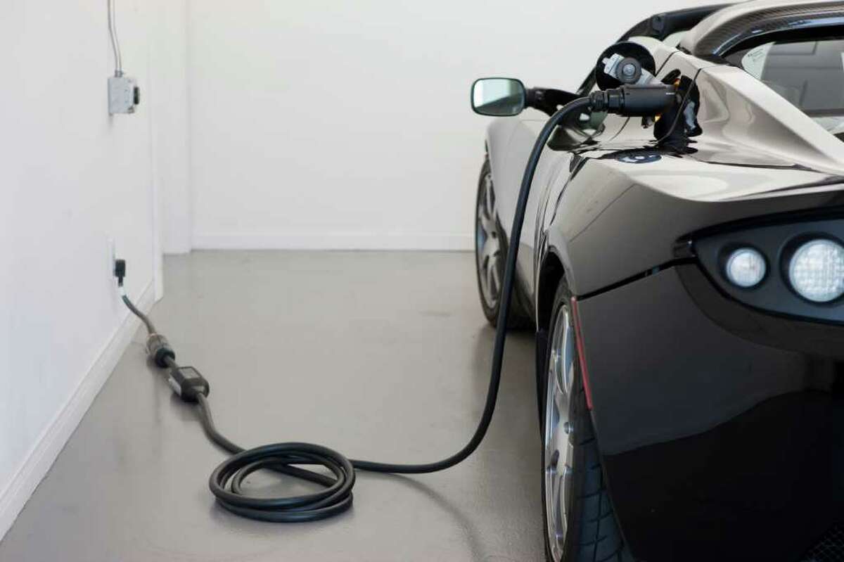 After a hard day's drive, a Tesla nurses gently from a wall outlet to once again get ready for the road.