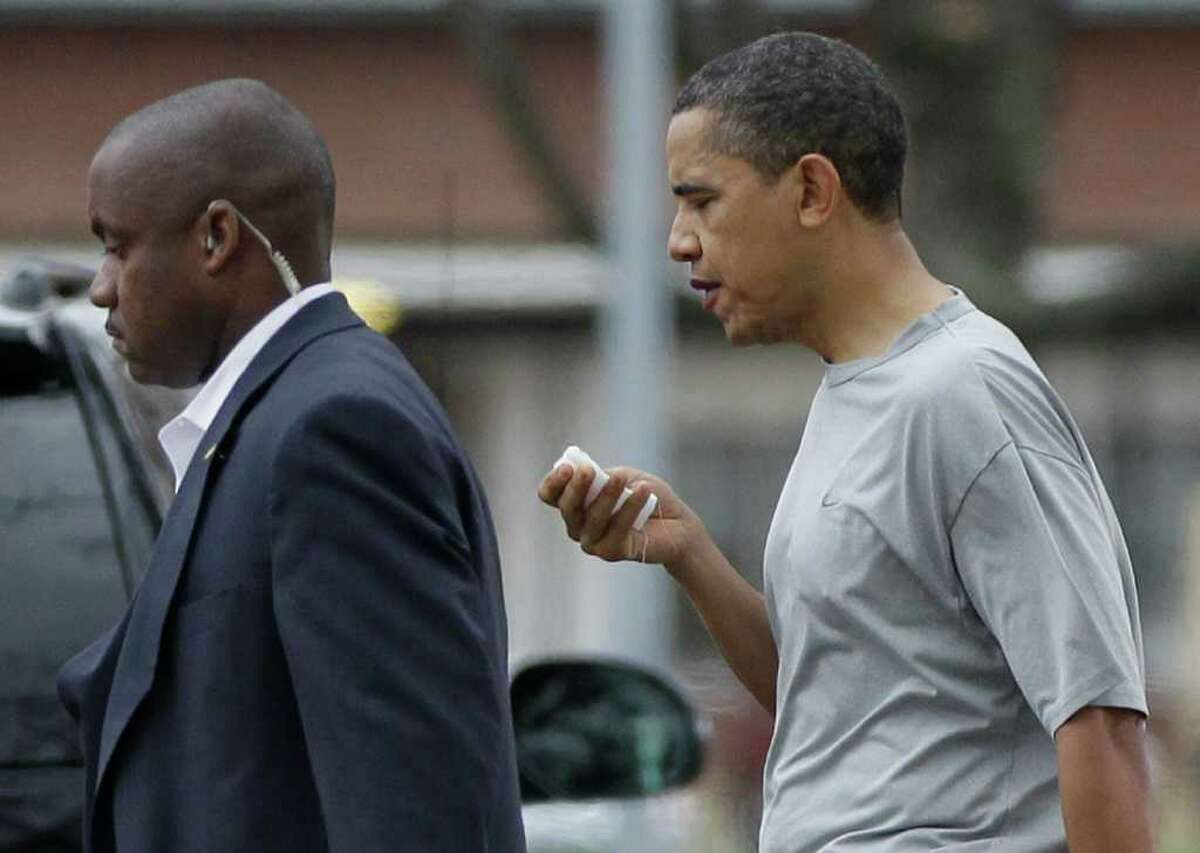 President Barack Obama walks with a U.S. Secret Service agent back to his vehicle after playing a private game of basketball at Fort McNair in Washington, Friday, Nov. 26, 2010. (AP Photo/Charles Dharapak)