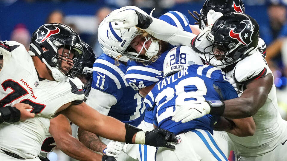 Houston Texans defensive tackle Tommy Togiai (72) and defensive end Will Anderson Jr. (51) stop Indianapolis Colts running back Jonathan Taylor (28) at the line of scrimmage during the second half of an NFL football game in Indianapolis, Sunday, Nov. 30, 2025.