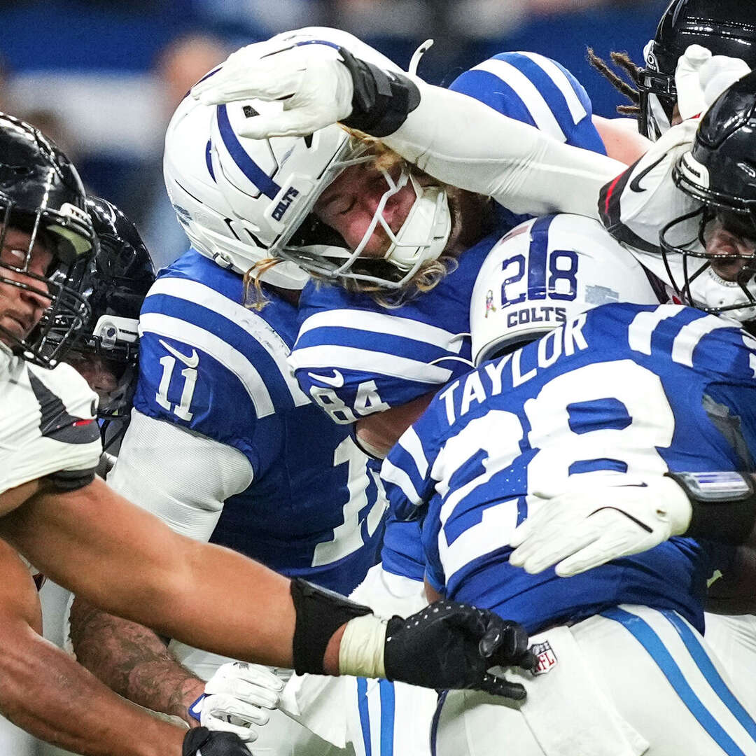 Houston Texans defensive tackle Tommy Togiai (72) and defensive end Will Anderson Jr. (51) stop Indianapolis Colts running back Jonathan Taylor (28) at the line of scrimmage during the second half of an NFL football game in Indianapolis, Sunday, Nov. 30, 2025.