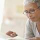 Woman wearing glasses reading a book.