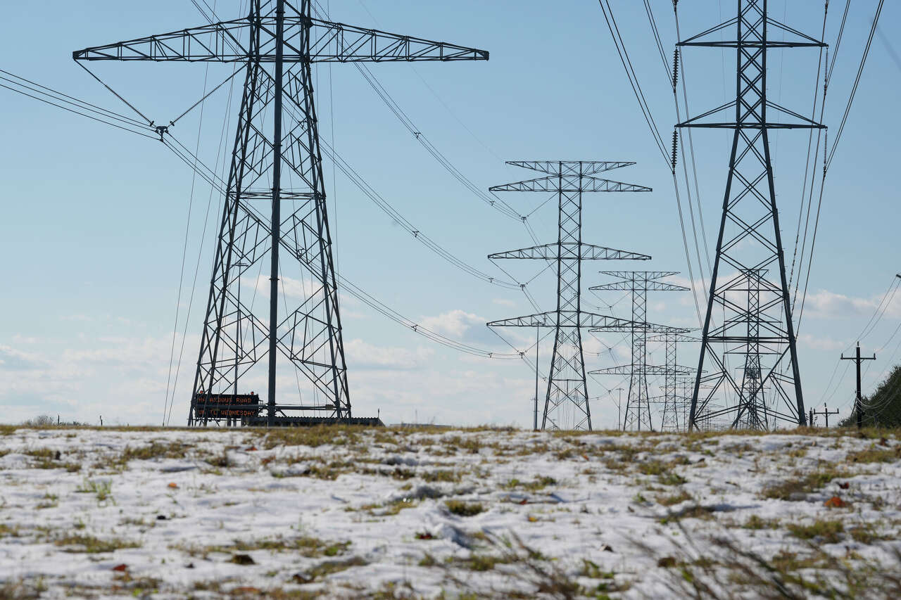 Transmission lines with snow on the ground is shown along the North Sam Houston Parkway near SH249 Tuesday, Jan. 21, 2025, in Houston.