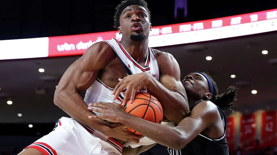 Houston Cougars center Cedric Lath (8) and Jackson State Tigers forward Raevon Thomas (20) battle for the rebound during the second half of an NCAA college basketball game, Wednesday, Dec 10, 2025, in Houston. (AP Photo/Maria Lysaker)