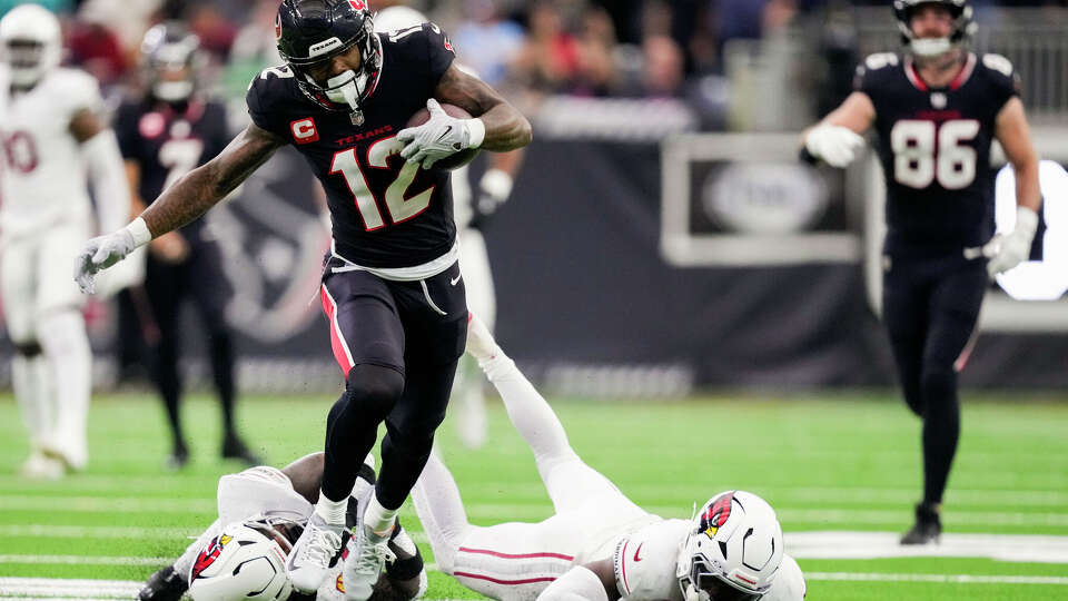 Houston Texans wide receiver Nico Collins (12) takes a pass by quarterback C.J. Stroud for a 57-yard touchdown during the first half of an NFL football game at NRG Stadium in Houston, Sunday, Dec. 14, 2025.