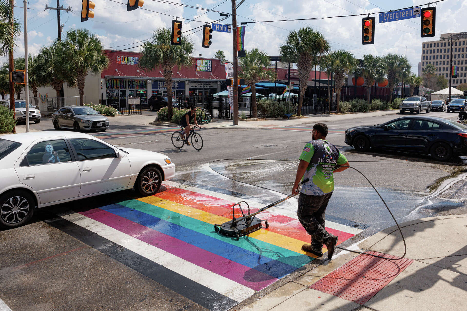 Traffic flows through the intersection of North Main and Evergreen Streets as Julian Antu from ProGreen Clean pressure washes the Pride crosswalk on Thursday afternoon, Oct. 9, 2025. Antu said that the local pressure washing company he works for is hired to clean the crosswalk every several months to keep it well-maintained.