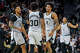 San Antonio Spurs guard Stephon Castle (5), forward Julian Champagnie (30) and guard Dylan Harper (2) celebrate a basket by Harper during the second half of an NBA game in San Antonio, Thursday, Dec. 18, 2025. San Antonio beat Washington 119-94.