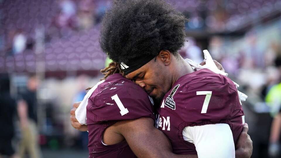 Texas A&M wide receivers KC Concepcion (7) and Mario Craver (1) embrace after the Aggies were eliminated from the College Football Playoffs with a 10-3 loss to Miami in College Station, Saturday, Dec. 20, 2025.