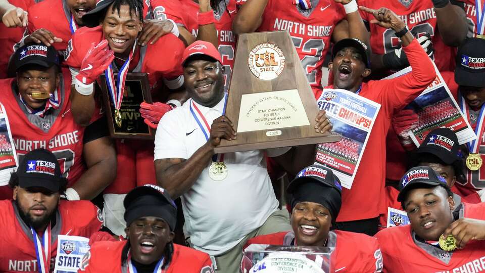 North Shore head coach Willie Gaston holds up the state championship trophy as he poses for photos with his team after a 10-7 victory over Duncanville in the 6A Division I football state championship game at AT&T Stadium on Saturday, Dec. 20, 2025, in Arlington.