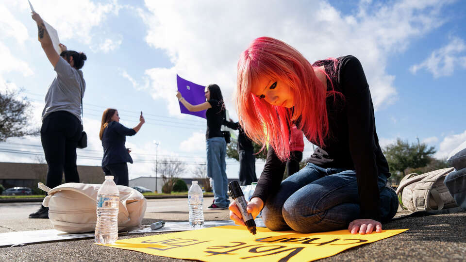 Serenity Wynn makes a sign to hold up as she joins Ross S. Sterling High School students and community members in front of Ross S. Sterling High School, Thursday, Dec. 18, 2025, in Baytown. 16-year-old Andrew Meismer died Wednesday after reportedly being stabbed by another student during a fight.