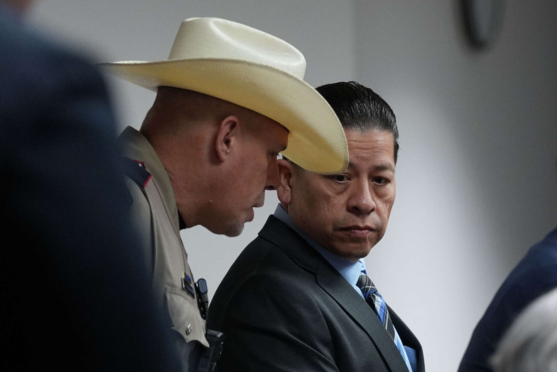 Former Uvalde school district police officer Adrian Gonzales, right, talks with an officer as he arrives in the courtroom at the Nueces County Courthouse in Corpus Christi, Texas, Tuesday, Jan. 6, 2026. (AP Photo/Eric Gay, Pool)