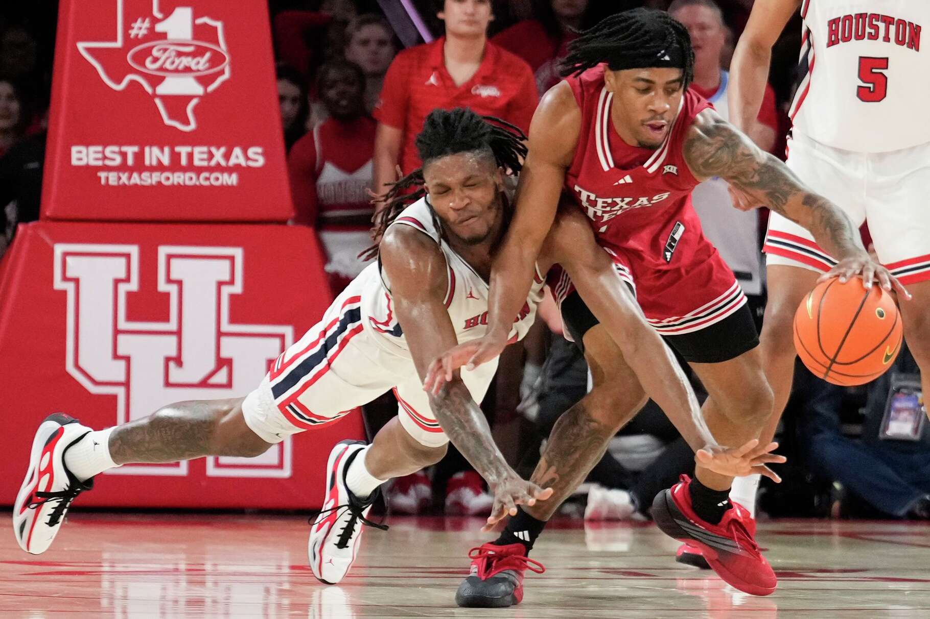 Houston forward Joseph Tugler (11) dives for a ball against Texas Tech forward JT Toppin (15) during the second half of an NCAA college basketball game at Fertitta Center in Houston, Tuesday, Jan. 6, 2026.