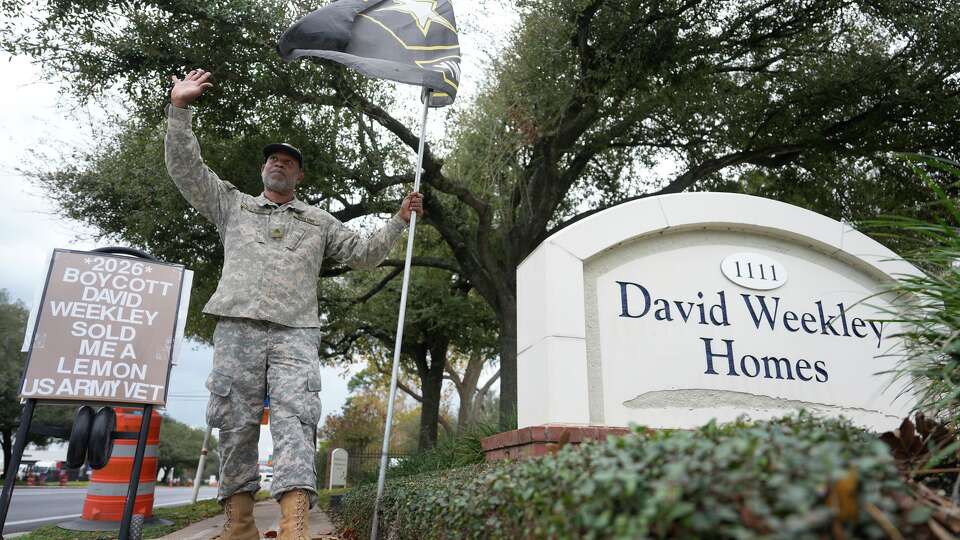 Retired Army veteran, Raymond Barlowe, of Mansfield, waves to passerby as he protests outside of the David Weekley Homes headquarters in Houston Thursday, Jan. 8, 2026. He is alleging that his new home and the entire subdivision in Mansfield is already visibly in disrepair because of shoddy workmanship.