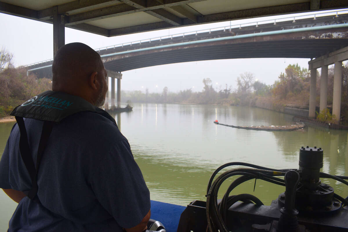 David Rivers, known as Bayou Dave, pilots the Bayou-Vac, a barge the Buffalo Bayou Partnership uses to clean trash out of the bayou.