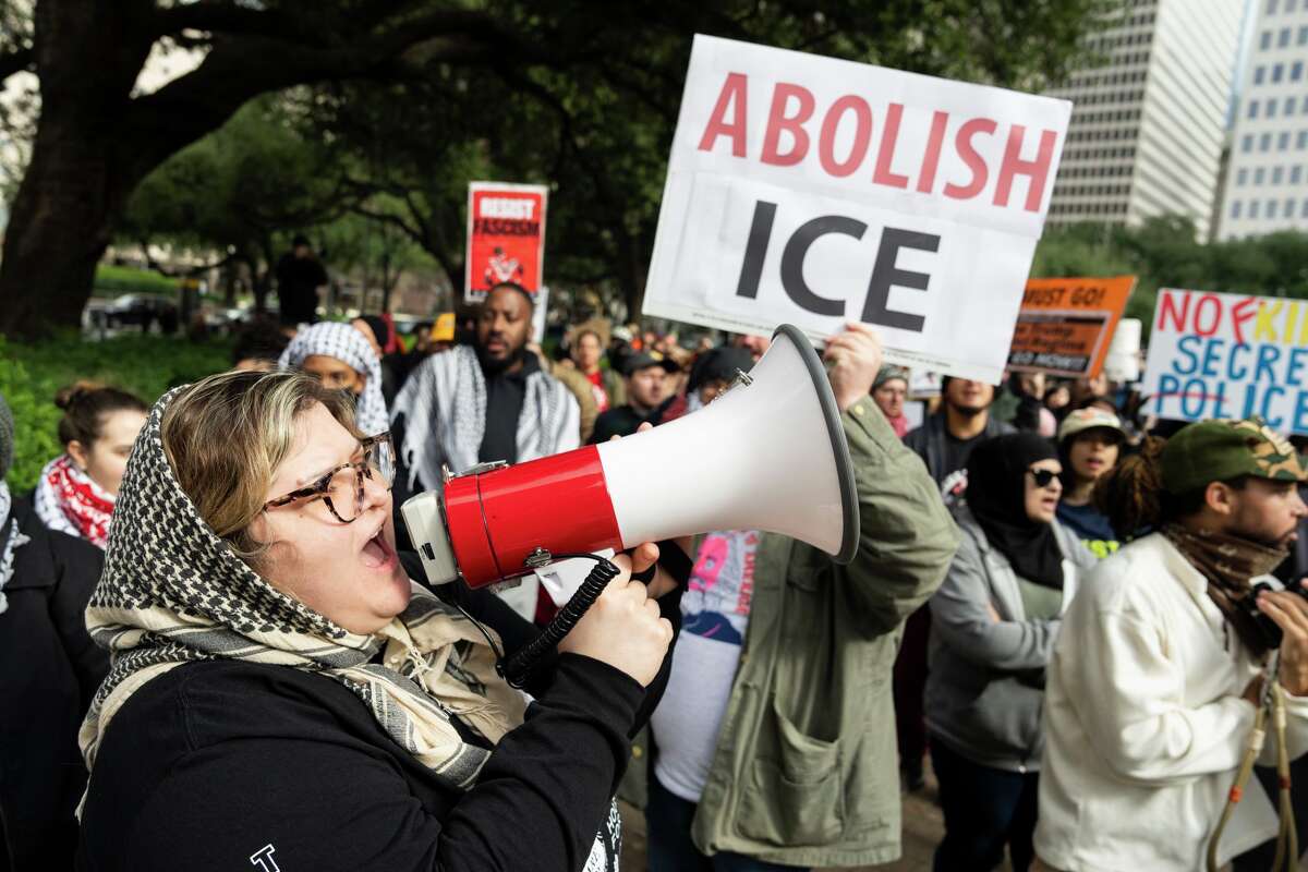 Carolina Martinez shouts into a megaphone as she and others protests against the deaths of Keith Porter and Renee Nicole Goode during ICE raids targeting undocumented immigrants and U.S. President Donald Trump’s military actions in Venezuela in front of City Hall in Houston, Saturday, Jan. 10, 2026.
