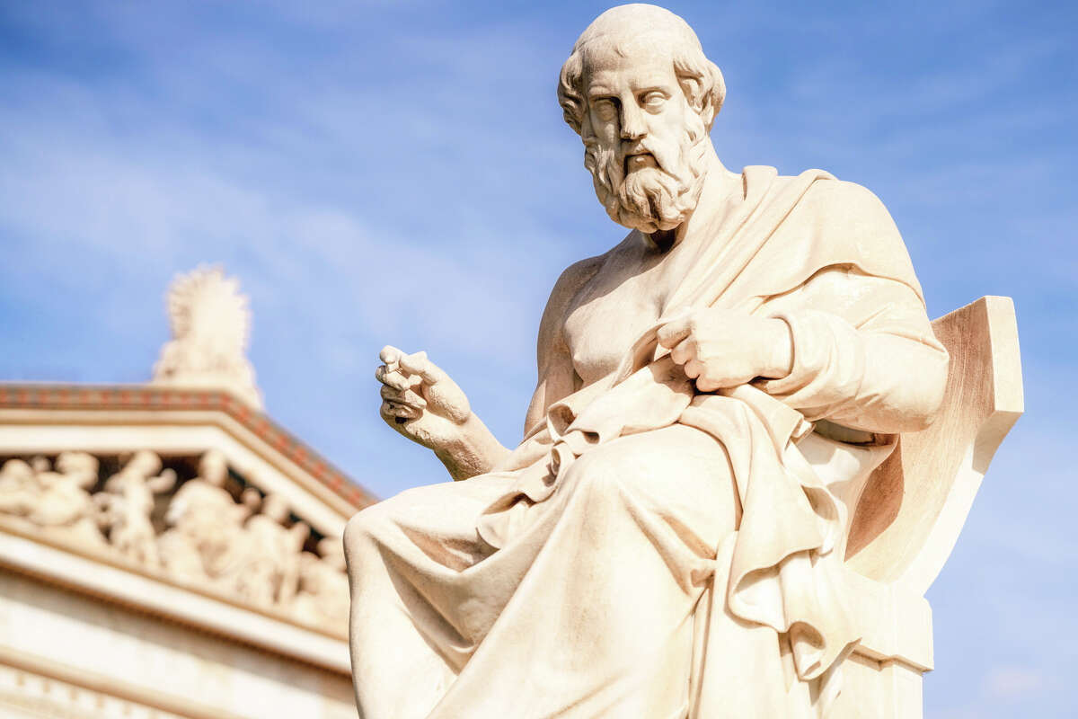 The marble statue of the ancient Greek philosopher Plato, with the front of the Academy of Athens in the background. The statue was completed in 1885 by Leonidas Drosis.
