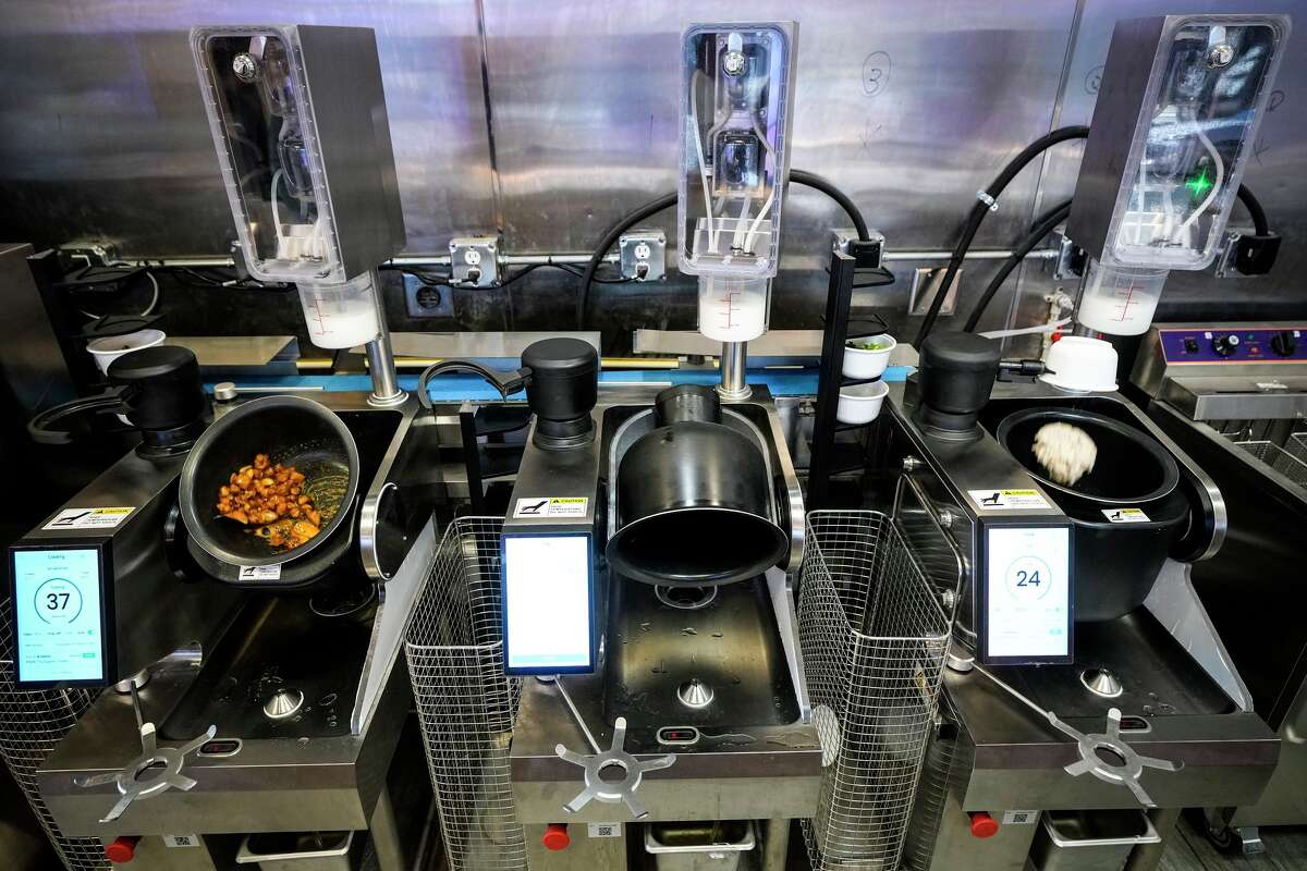 Food is cooked at iWok, a new fast-casual Asian restaurant that uses robots to make the food and boba drinks, in Houston, Thursday, Jan. 15, 2026.
