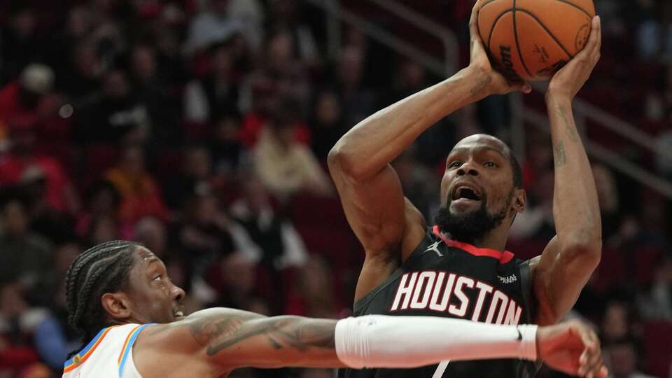 Houston Rockets forward Kevin Durant (7) struggles to get a shot up around Oklahoma City Thunder guard Jalen Williams (8) at the Toyota Center in Houston on Thursday, Jan. 15, 2026.