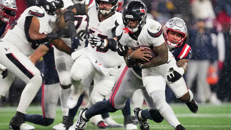 Houston Texans running back Woody Marks (27) is tackled by New England Patriots linebacker Jahlani Tavai (48) during the second half of an NFL divisional playoff football game in Foxborough, Mass., Sunday, Jan. 18, 2026.