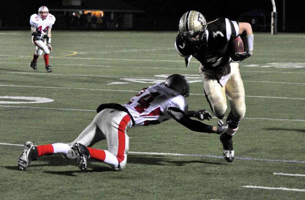 Trumbull's Phil Terio avoids Conard's Anthony Lugo defense during the CIAC quarterfinal football game at Trumbull on Tuesday, Nov. 30, 2010.