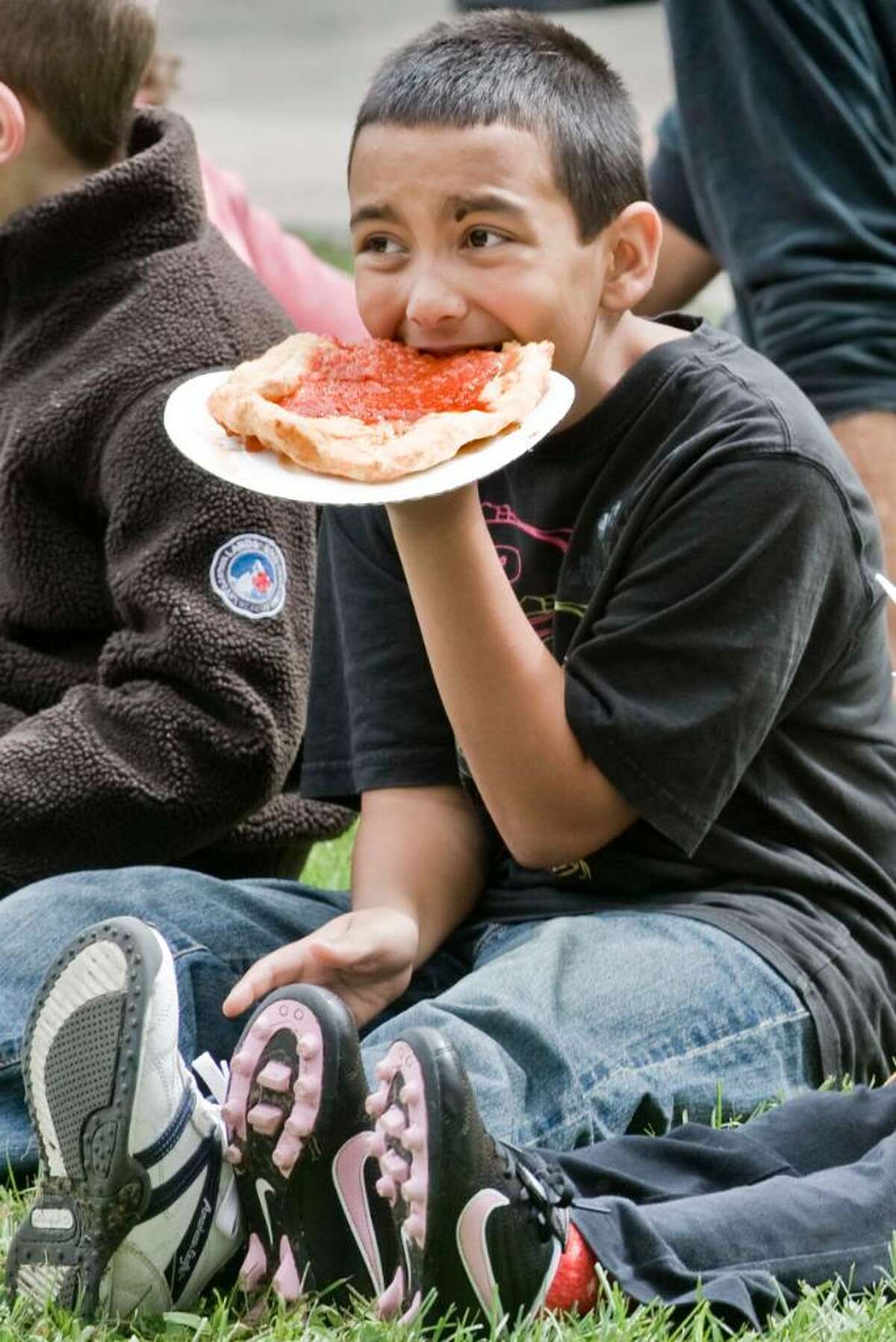 10 year old Andrew Larkin of New Milford enjoys a bite while watching the festivities during the Taste of Danbury at the CityCenter Green. Saturday, Sept. 12, 2009