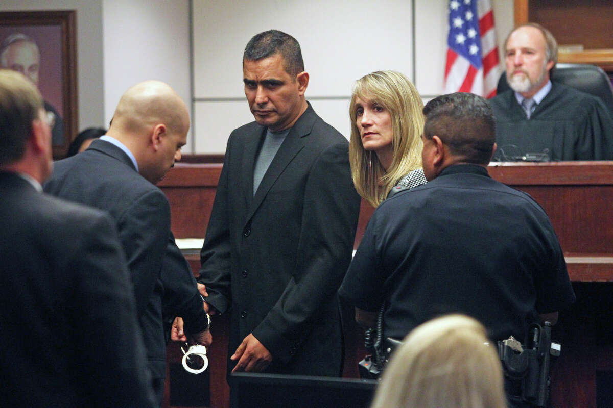 With defense attorneys Roland Garcia (left) and Carolyn Wentland bracketing their client, handcuffs are placed on former SAPD officer David Seaton after his sentence was read.