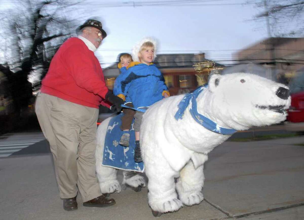Bobby Jones, 4, front, and his brother, Mason, 3, of Greenwich, ride the mechanical polar bear with the help of Bob Meyer during the annual tree-lighting ceremony at Greenwich Town Hall, Friday afternoon, Dec. 3, 2010.