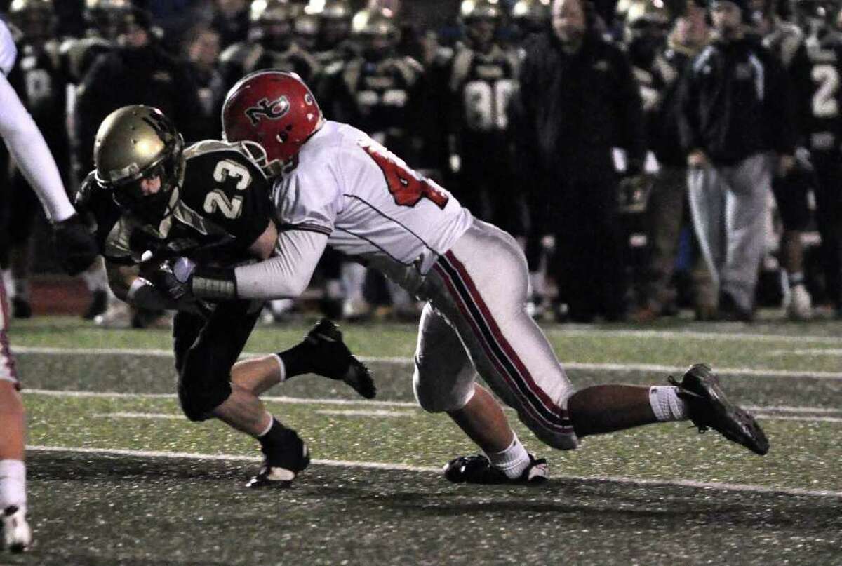 New Canaan's Kevin McDonough (49) tackles Daniel Hand's Chad Crisco (23) during the CIAC Class L semifinals against Daniel Hand at Ken Strong Stadium in West Haven on Saturday, Dec. 4, 2010.