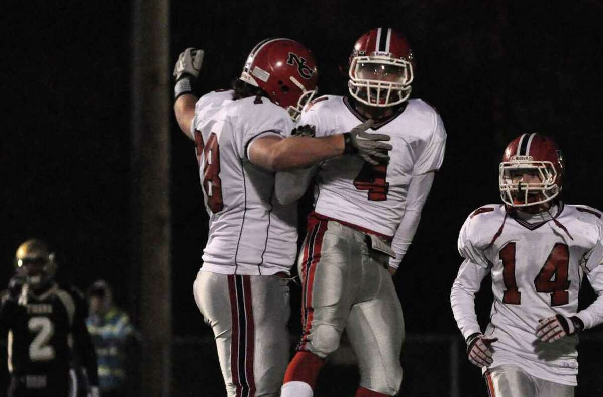 New Canaan's Conor Hanratty (78) congratulates teammate Kevin Macari (4) on a touchdown during the CIAC Class L semifinals against Daniel Hand at Ken Strong Stadium in West Haven on Saturday, Dec. 4, 2010.