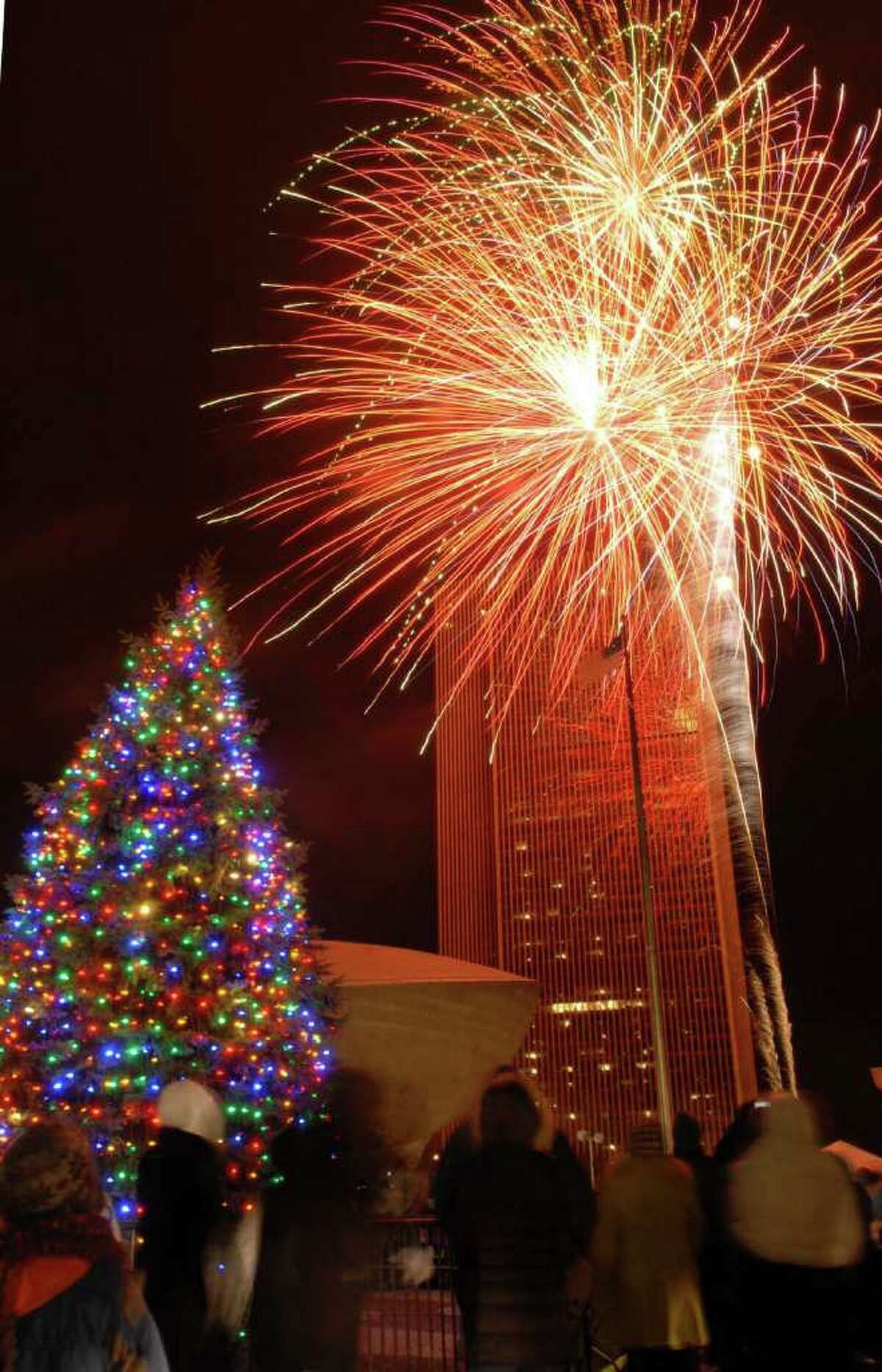 Just as the New York State Tree lights up with more than 2,000 energy-efficient light-emitting diodes, the crowd at Empire State Plaza was treated to a fireworks display to honor the holiday tree-lighting on Sunday, Dec. 5, 2010, in Albany, NY. (Luanne M. Ferris / Times Union )