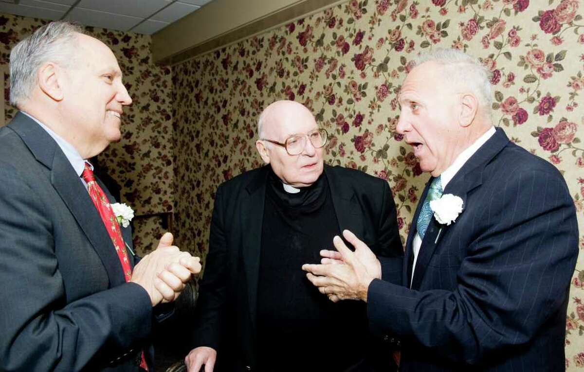 Honorees Richard Rosum, left, and his brother Paul Rosum, right, chat with their cousin Father Robert Hyl as the Stamford Old Timers holds its 68th annual dinner at the Italian Center in Stamford, Conn., Monday, December 6, 2010. Proceeds help fund scholarships for local Scholar-Athletes and sponsorship to area sports teams.