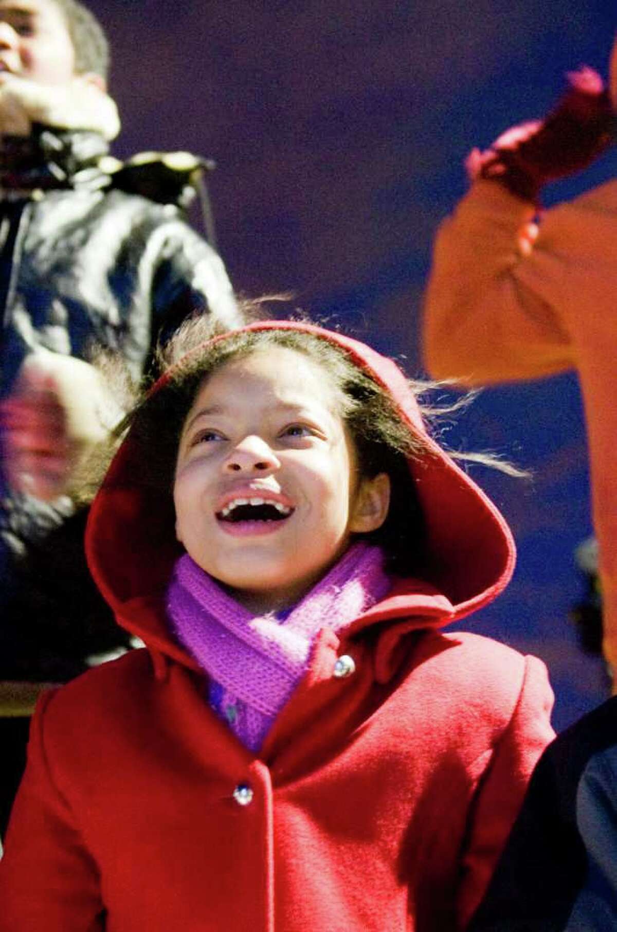 The Waterside School's Sarah Gordon, front row left, Olivia Davis and Charles Tate react to the tree lighting as Building and Land Technology, the developer of Harbor Point, hosts a tree-lighting ceremony for the first time in Commons Park, a public space newly built as part of Harbor Point in Stamford, Conn., Monday, December 6, 2010.