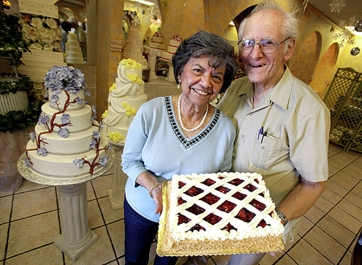 Hans Nadler, right, and his wife Minerva hold their signature cake, Strawberry Shortcake, which they have been making for more than 40 years.