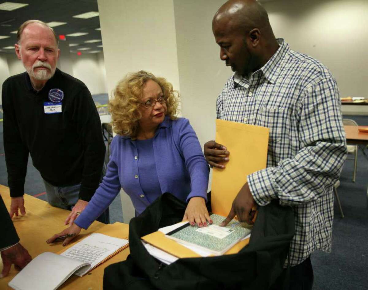 From left; Volunteer Jack Wentland of Glastonbury looks on as Bridgeport Democratic Registrar of Voters Santa Ayala and James Mullen of Bridgeport open a bag of ballots during the election recount at the City Hall Annex in Bridgeport on Tuesday, November 30, 2010.