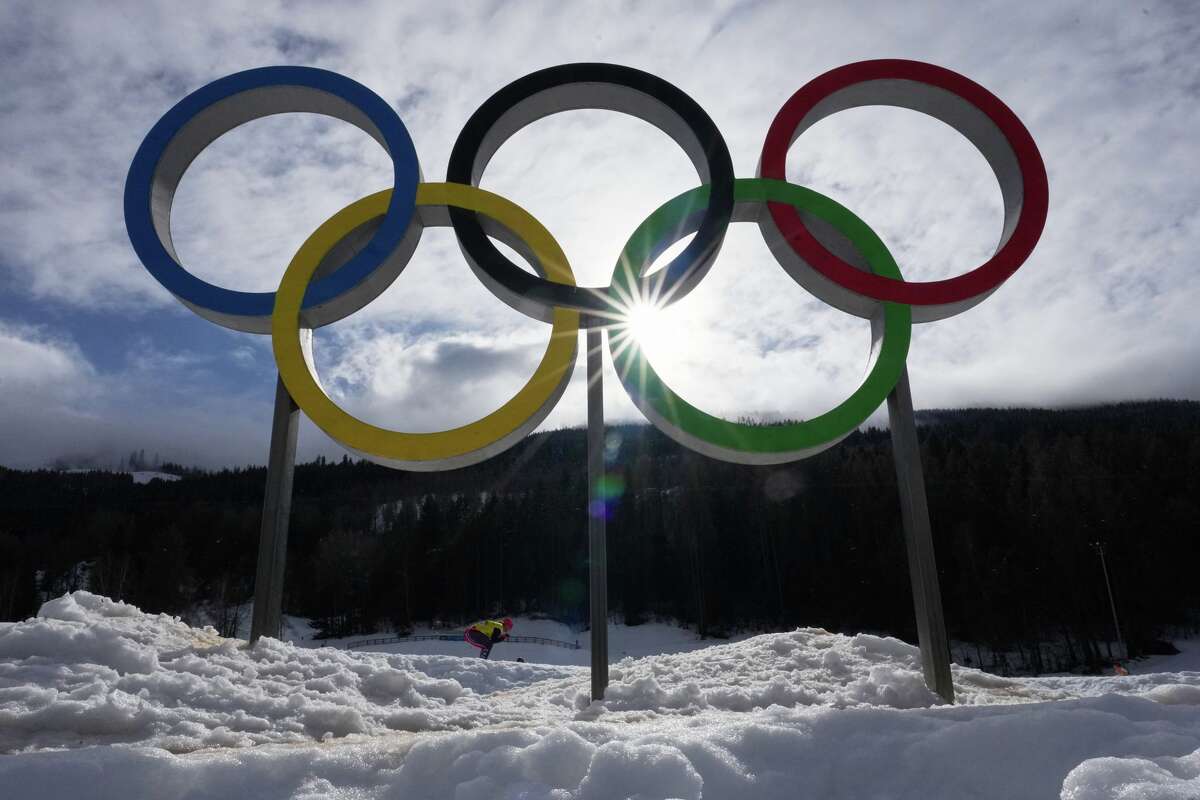 An athlete skis past Olympic rings during a cross country training session at the 2026 Winter Olympics, in Tesero, Italy, Thursday, Feb. 5, 2026.