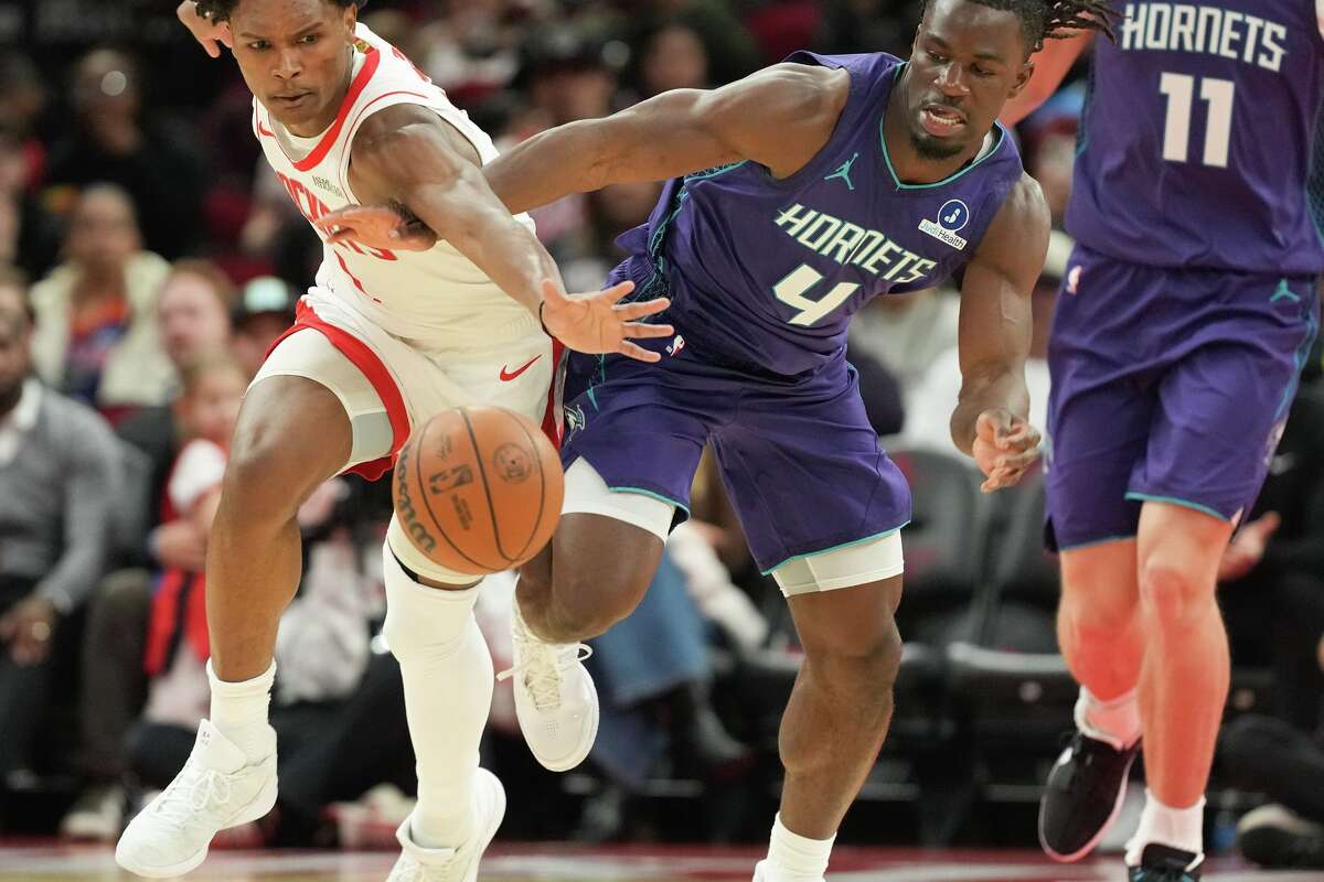 Houston Rockets guard Amen Thompson (1) and Charlotte Hornets guard Sion James (4) chase after a loose ball in the fist half of game action at the Toyota Center in Houston on Thursday, Feb. 5, 2026.